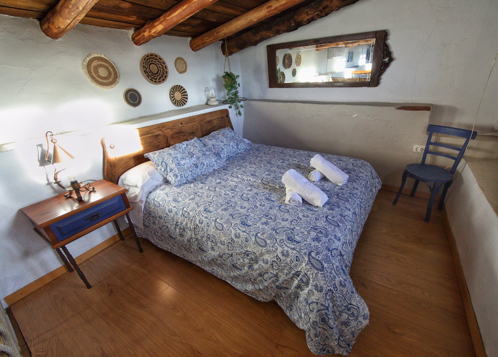 Amplia buhardilla con cama de matrimonio y dos individuales bajo techo de madera. Habitación buhardillada con techo de madera, una cama de matrimonio y dos camas individuales en Mirador de Santa Ana.