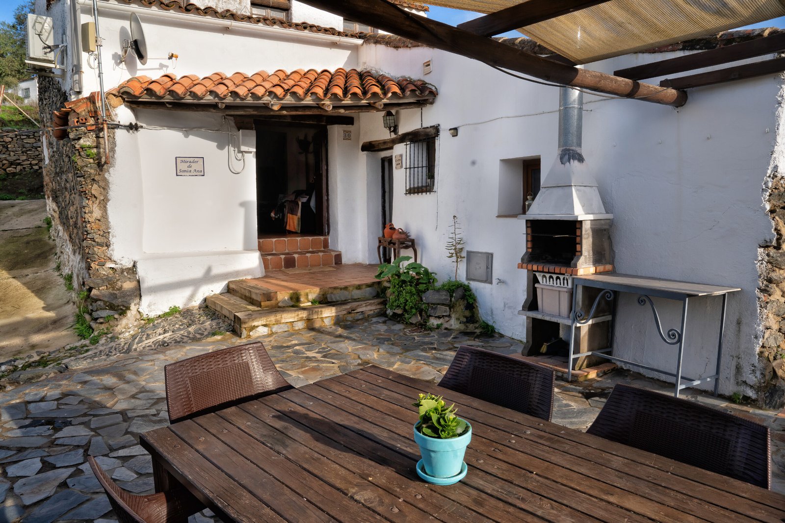 Área de barbacoa con mesa de comedor al aire libre Patio con barbacoa y zona de comedor exterior en casa rural tradicional